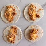 Four bean and cheese burritos on a white background