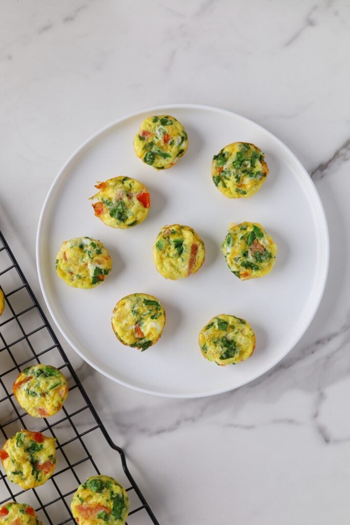 Several spinach egg bites on a white plate
