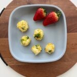 Easy Broccoli rice balls on a plate with two strawberries